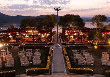 An evening view of a lakeside venue in Udaipur, with twin mandaps glowing under the twilight sky. We select and style venues to maximize their natural beauty, especially during golden hour.