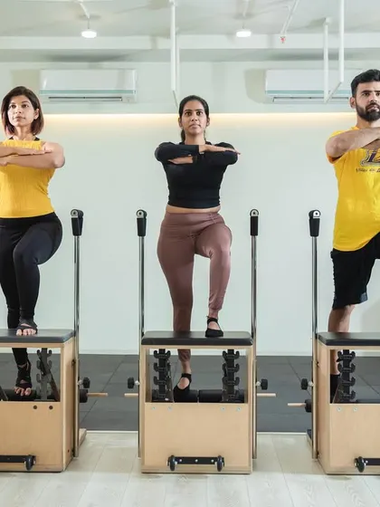 Our instructors demonstrating perfect synchronized form on the Pilates Chairs. We prioritize safety and confidence in every class.