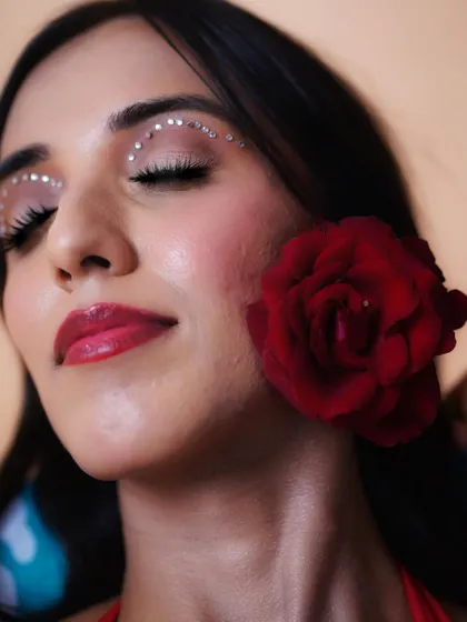 A close-up of the creative eye makeup with rhinestones. This is a great way to add a unique and artistic touch to a photoshoot.
