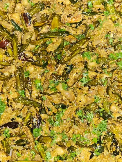 A dry vegetable preparation, possibly a stir-fry with beans, garnished with fresh coriander.