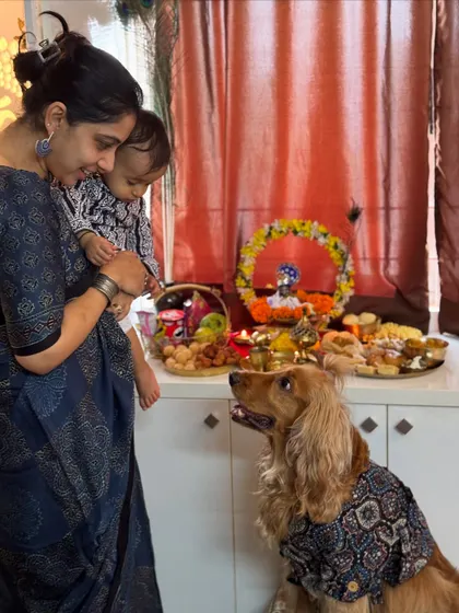 A sweet moment between mother, son, and fur-son during the Janmashtami puja.