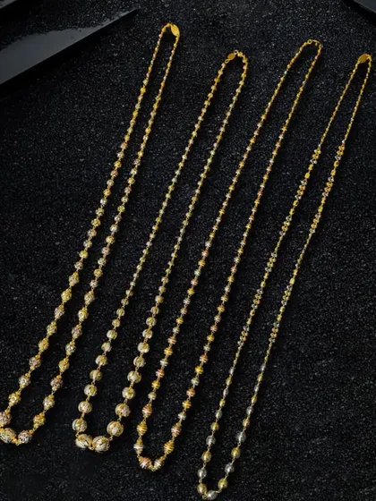 Here, I've arranged four distinct chain styles on a black textured surface. The contrast makes the gold pop, and the diagonal layout guides the viewer's eye across each piece.