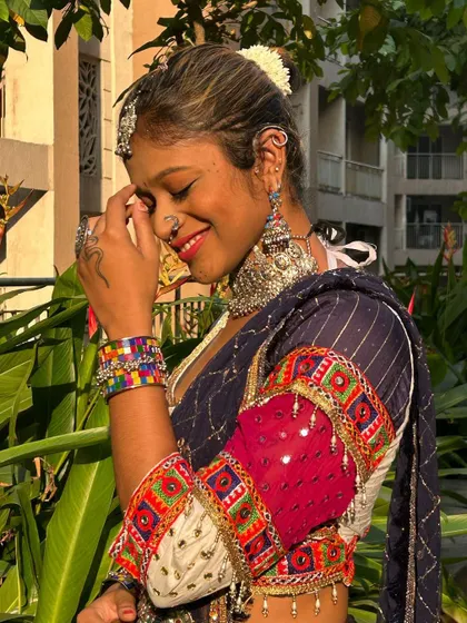 A smiling shot showing off the complete look, including a maang tikka, choker, and colorful bangles that complement this 'Gangubai' inspired outfit.