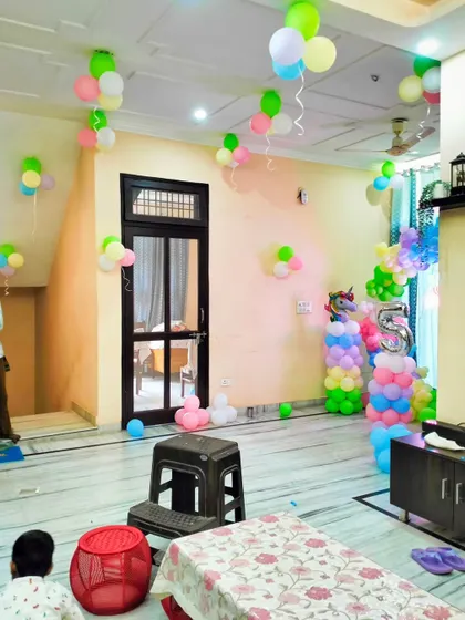 A wider view of a home decorated for a unicorn-themed party. You can see how the main backdrop, balloon pillars, and ceiling balloons all work together to create a cohesive and magical environment.