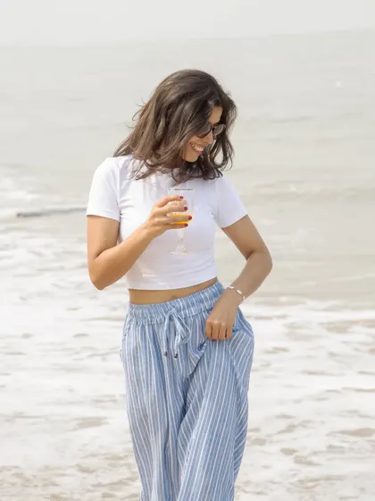 A happy, candid shot of me enjoying a drink on the beach, perfect for a summer lifestyle or travel campaign.