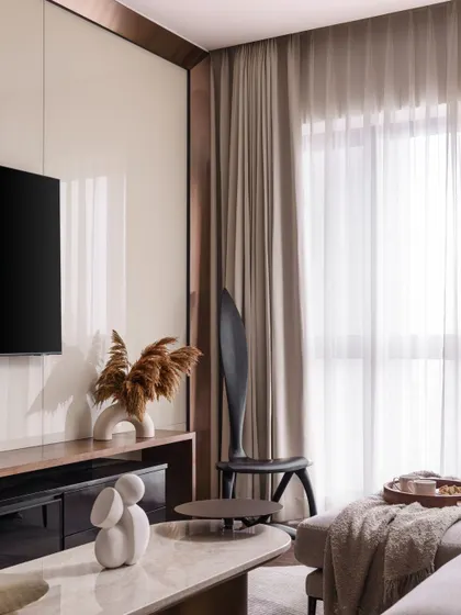 Another view of the TV area, highlighting the clean lines and the contrast between the glossy panel and the soft, matte textures of the sofa and curtains.