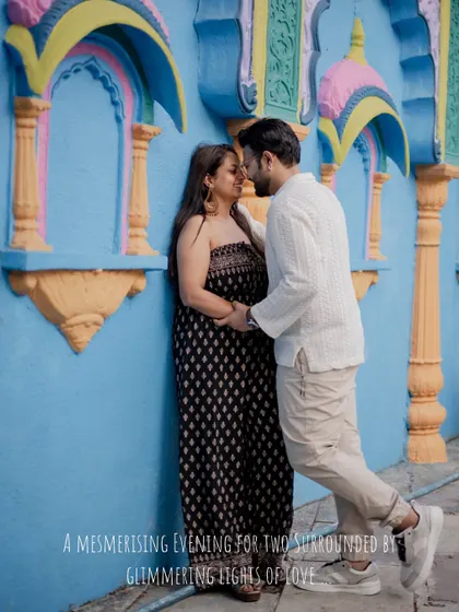 An intimate pre-wedding portrait of the couple against a colorful blue wall, capturing a quiet moment of love.