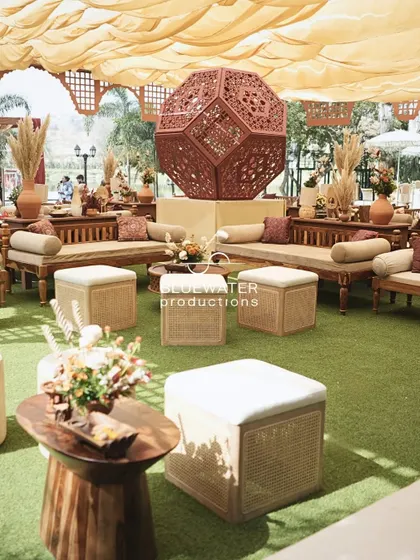 A comfortable and stylish lounge area for the Souk-themed event, with low wooden seating, cane poufs, and a large geometric art installation.