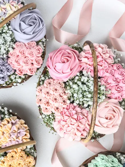 An overhead view of several completed cupcake baskets, showcasing a range of pastel color schemes. The delicate baby's breath and pink ribbon add a final touch of elegance.