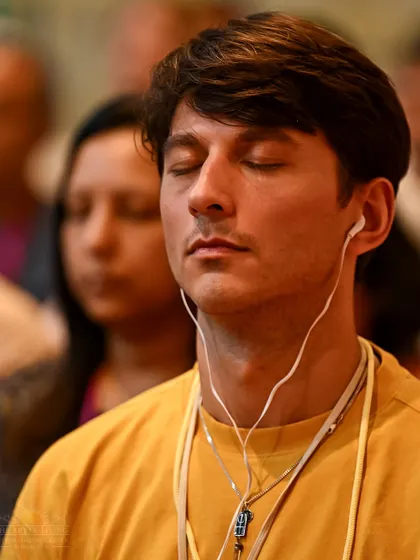 A young man listens to a translated discourse on headphones while meditating. We provide translation services for many of our key programs to make this ancient wisdom accessible to a global audience.