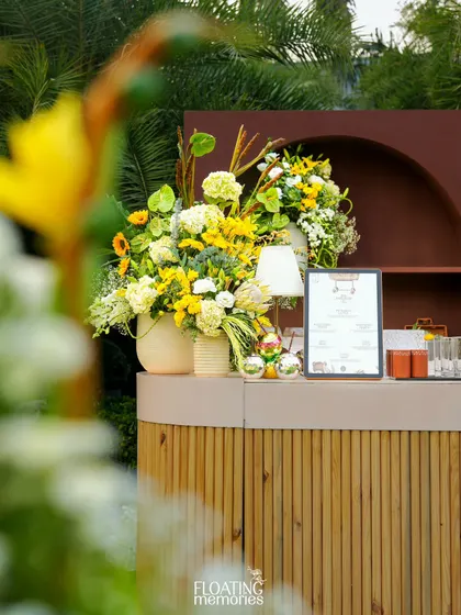 A closer look at the stunning floral arrangements on the bar. The mix of yellow, white, and green blooms adds a burst of freshness and luxury to the beverage station.
