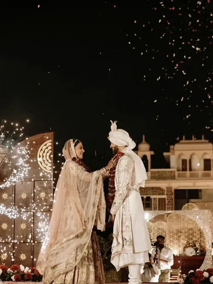The couple shares a quiet moment during their Varmala ceremony, with spinning pyrotechnics creating a magical, starry effect around them.