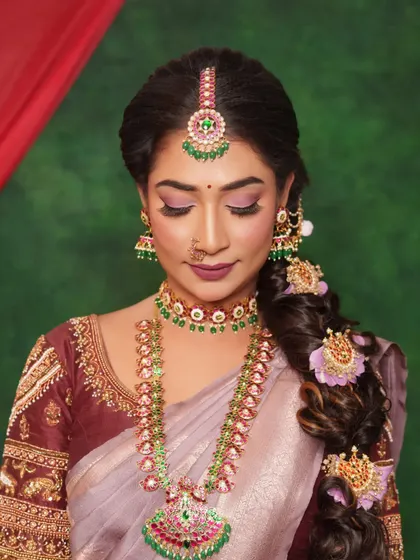 A detailed close-up of this elegant Muhurtham look. You can see the soft blend of the eyeshadow, the perfectly placed bindi, and how the jewellery's colors are echoed in the makeup.