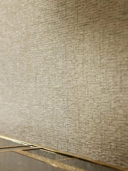 A close-up of the “Lioube” wallcovering. The intricate weave and shimmering lurex threads are visible, showcasing the high-quality texture that defines this luxurious design.