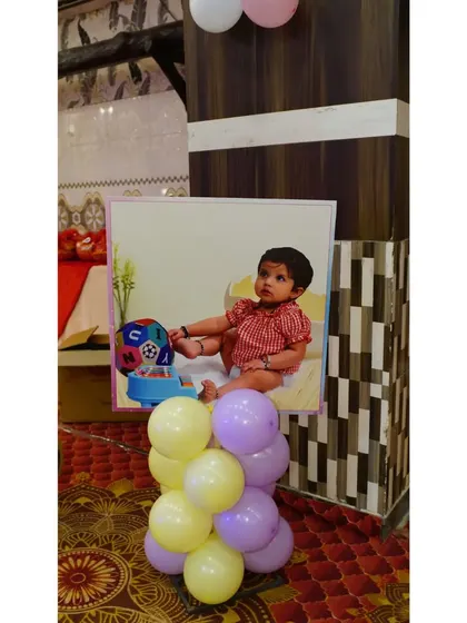 Personalized photo stands are a great way to decorate the party space. This one features a cute picture of the birthday girl, adding a personal and sweet touch to the venue.