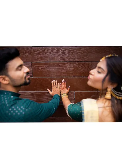 A fun and creative engagement portrait where the couple playfully interacts with a wooden wall, showing their fun-loving personalities.