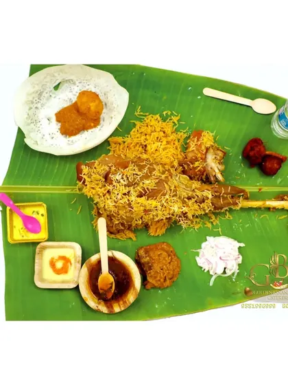 This is the full Raja Virundhu spread for one person. It features a mutton leg, biryani, appam, chicken 65, and other delicacies on a fresh banana leaf.