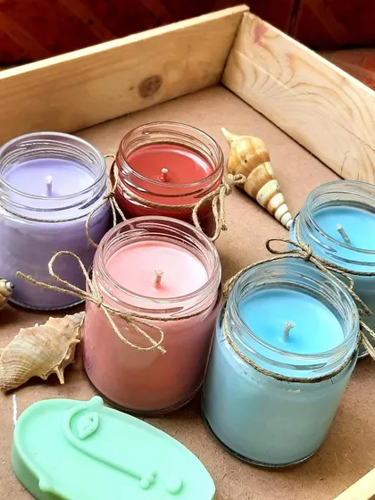 A collection of my custom scented candles in mini jars. You can choose from a variety of colors and fragrances to create your perfect candle.