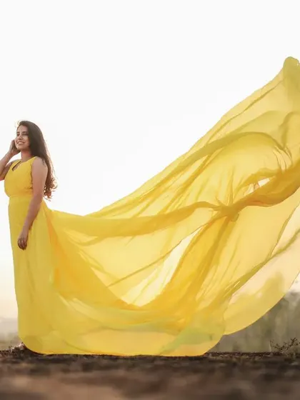 Capture that golden hour magic with this bright yellow tail gown. The long, airy tail is designed to catch the light and wind, creating an effortlessly beautiful and ethereal look for your pre-wedding shoot.