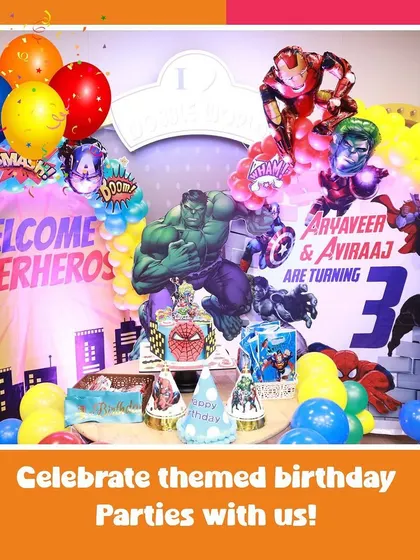 A full view of our action-packed superhero theme. The backdrop features Hulk and Iron Man, with a cake table ready for the celebration.