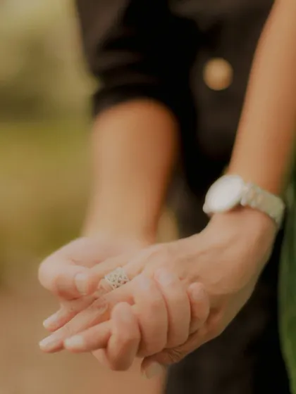 A close-up shot of the couple's hands intertwined, a simple yet powerful symbol of their bond.