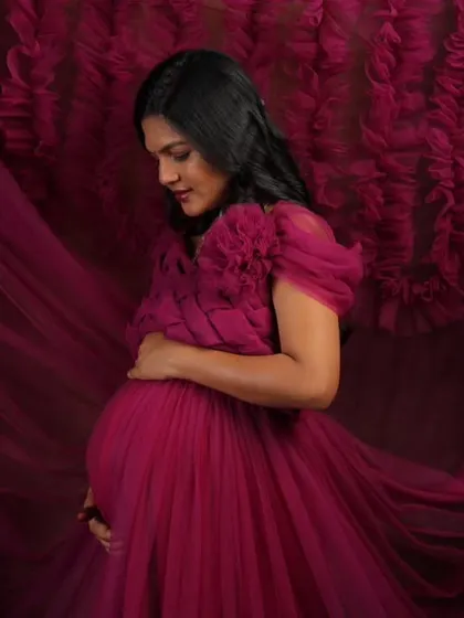 This studio shot showcases the incredible texture and flow of my magenta ruffled maternity gown. The rich color and voluminous fabric create a dramatic and artistic portrait for your pregnancy photoshoot.