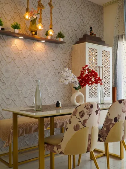 A look at the elegant dining area from a satisfied client's home, featuring a textured wall, stylish chairs, and a beautiful pooja unit in the background.