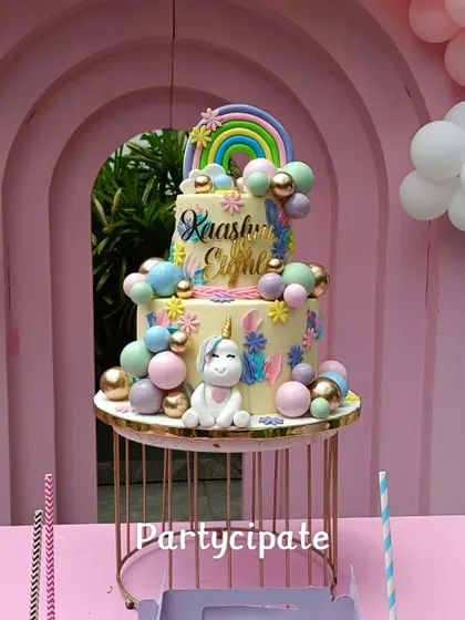 The magical unicorn cake for Kaashni's eighth birthday. This three-tiered cake is adorned with a rainbow, clouds, and a sweet unicorn topper.