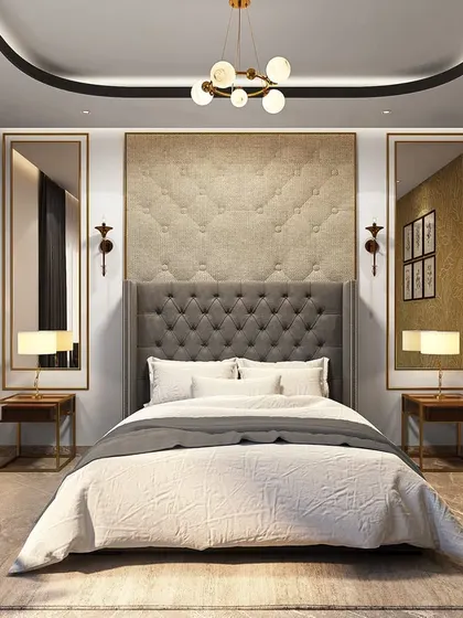 This bedroom design uses symmetry and texture to create a sense of luxury. The tufted grey headboard is flanked by tall mirrors and elegant wall sconces, while the gold-patterned wallpaper adds a touch of opulence.