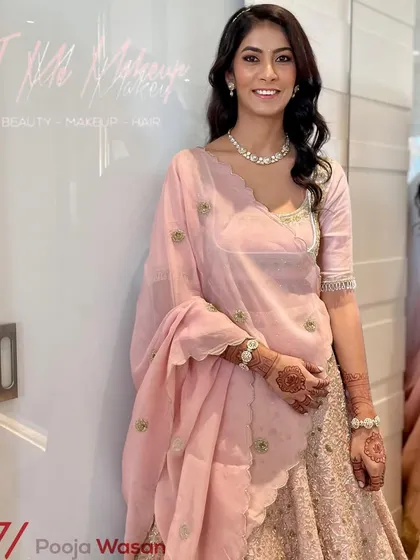 Elegance in pastel pink. This soft and sophisticated look is perfect for a day wedding or a reception, featuring gentle waves and natural-looking makeup that enhances her features.