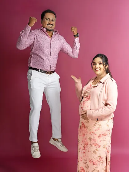 We love capturing your joy. The dad-to-be jumps for excitement in this fun and energetic shot against a solid pink background.