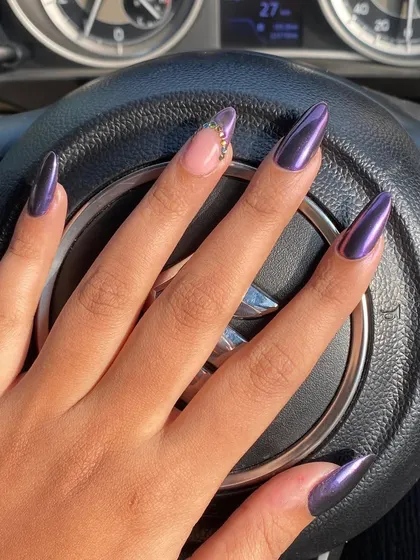 Sleek and powerful, these stiletto nails feature a deep purple chrome finish that shines from every angle. A single accent nail with delicate rhinestone detailing adds a touch of refined glamour.