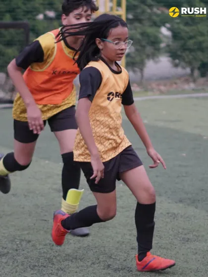 A female player keeps pace with a teammate during a running drill.