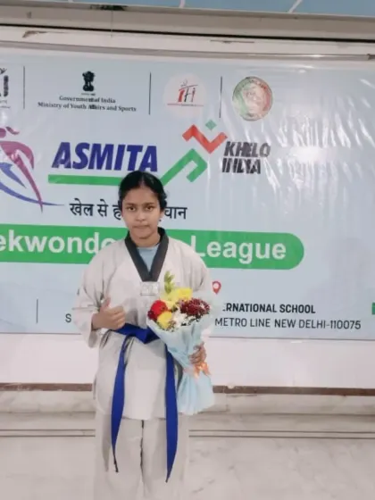 A blue belt student holding a bouquet after her performance at the Asmita City League. We celebrate the efforts of all our students.