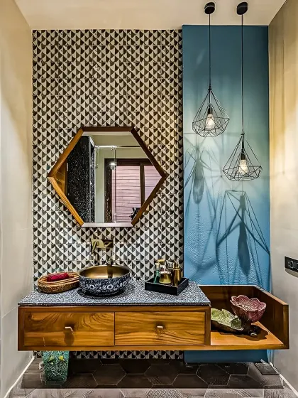 This powder room makes a bold statement with geometric patterned tiles and a vibrant blue accent wall. The hexagonal mirror and unique vessel sink add to the eclectic and stylish design.