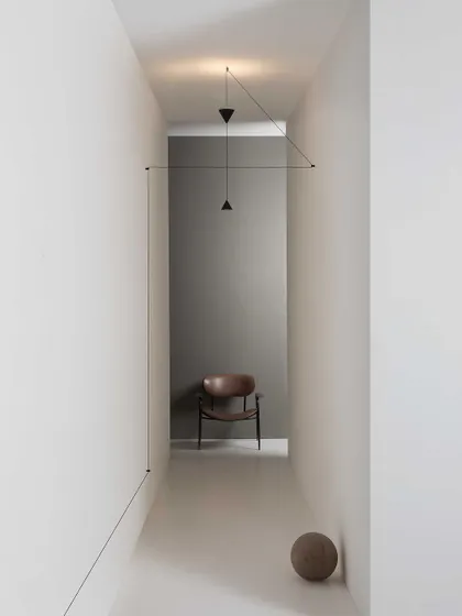 The Filomena system used to create a geometric installation in a narrow hallway. The wires and pendants become a piece of graphic art, transforming a simple corridor into a designed space.