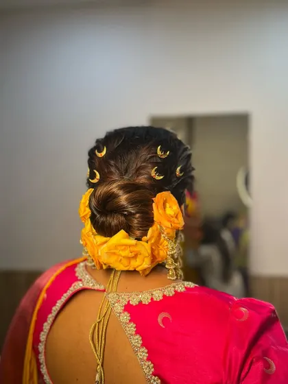 Another angle of the twisted bun with yellow roses. The twists create a beautiful texture that complements the softness of the rose petals, resulting in a fresh and youthful bridal hairstyle.