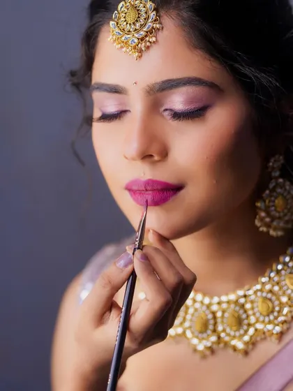 A close-up action shot of me applying the final touches to her lip. Precision is key for a perfect pout.