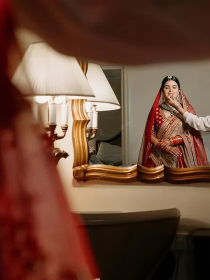 A reflection of the bride in a gilded mirror, a classic and elegant getting-ready shot.