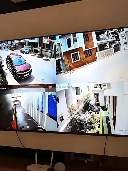A four-way split screen showing live feeds from multiple CCTV cameras around the property. This comprehensive view ensures all angles are covered.