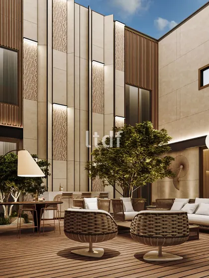 A different angle of the courtyard, showcasing the dramatic, multi-story feature wall with integrated lighting. The combination of smooth and textured panels with vertical wood slats creates a facade that is both monumental and rich in detail.