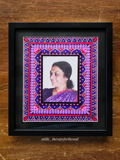 The finished mandala-framed photograph, presented in a classic black frame. The vibrant pink and purple patterns of the mandala beautifully complement the photo within.