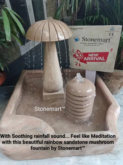A close-up of the rainbow sandstone mushroom fountain, highlighting the beautiful natural stone patterns and the soothing rainfall effect.