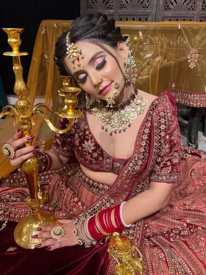 A creative pose with a candelabra, this image highlights the glowing skin and intricate details of the makeup and jewelry in this artistic bridal shoot.