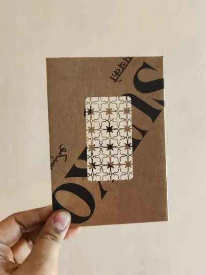 A handmade notebook with a unique patterned window on the cover.
