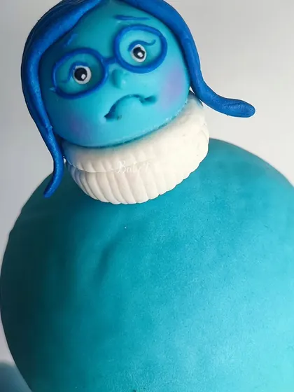 A close-up of the 'Sadness' figurine from the 'Inside Out' cake. Capturing the unique look and feel of each character is a challenge I absolutely love.