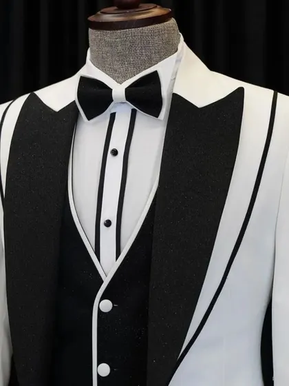 A striking white tuxedo with bold black lapels and piping. This is a classic Hollywood-style look, perfect for a black-tie event or a stylish reception.