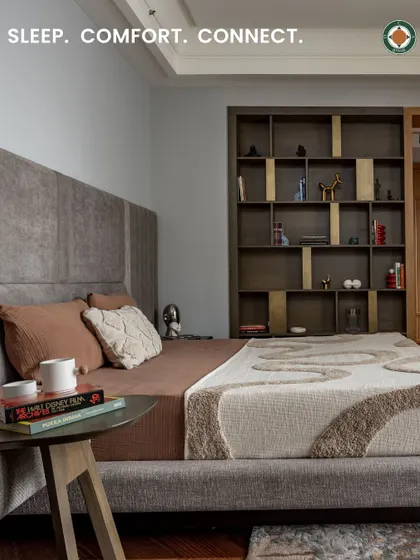 Each bedroom in the Aalay residence is a personal retreat designed for comfort and reflection. This parent's room uses a palette of muted greys and browns to create a sophisticated and calming atmosphere, complete with a bespoke upholstered bed and integrated shelving.