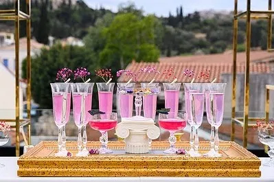 A closer look at the pink-themed cocktails for a destination wedding. The drinks are garnished with small flowers and custom butterfly tags, perfectly matching the romantic and whimsical decor.