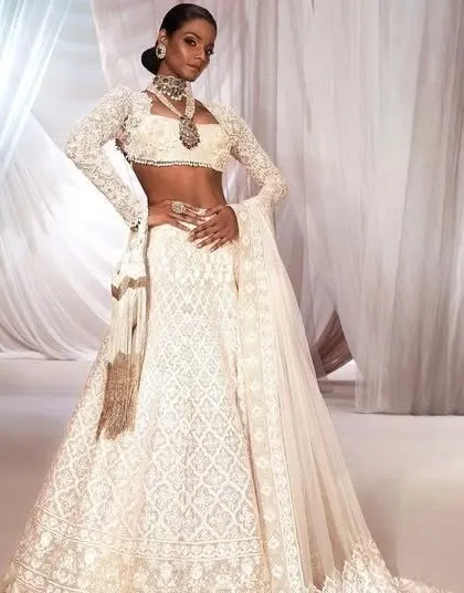 The classic all-white Chikankari-style lehenga is timeless. I can help you design a similar piece, focusing on intricate, delicate embroidery for a regal and elegant look.